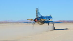 A blue and yellow airplane is on a runway
