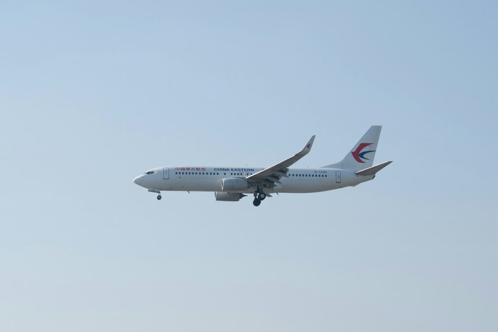A commercial airplane flying against a clear sky.