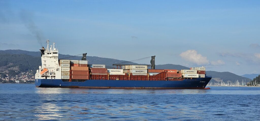 A cargo ship sails on the blue ocean.