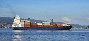A cargo ship sails on the blue ocean.