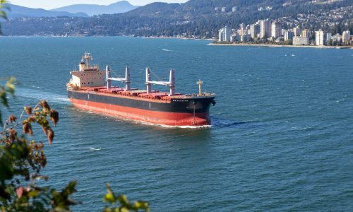 cargo ship sailing near city