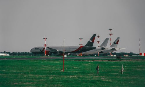 white and red airplane on green grass field during daytime